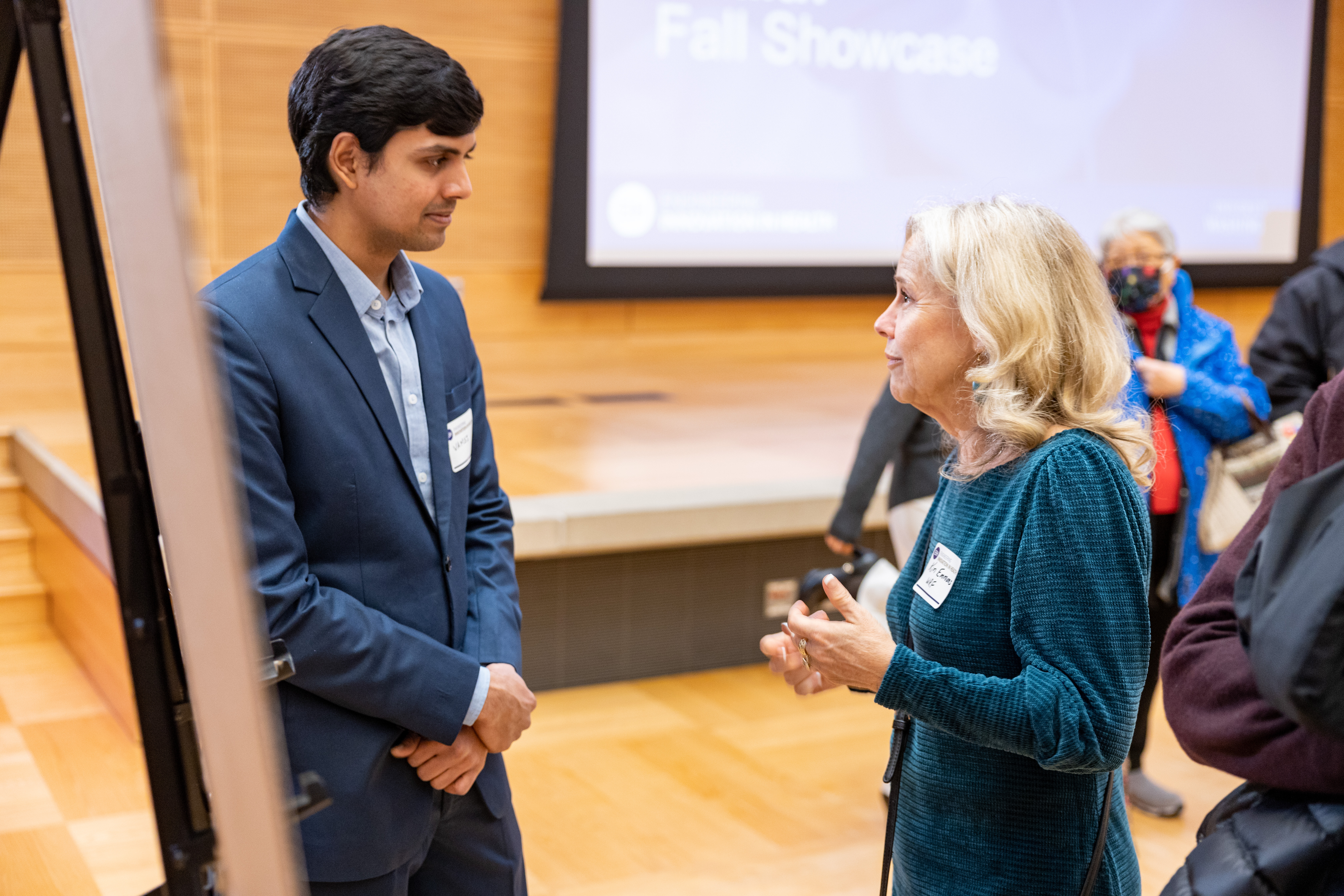 "Audience member asking a student questions about their project"