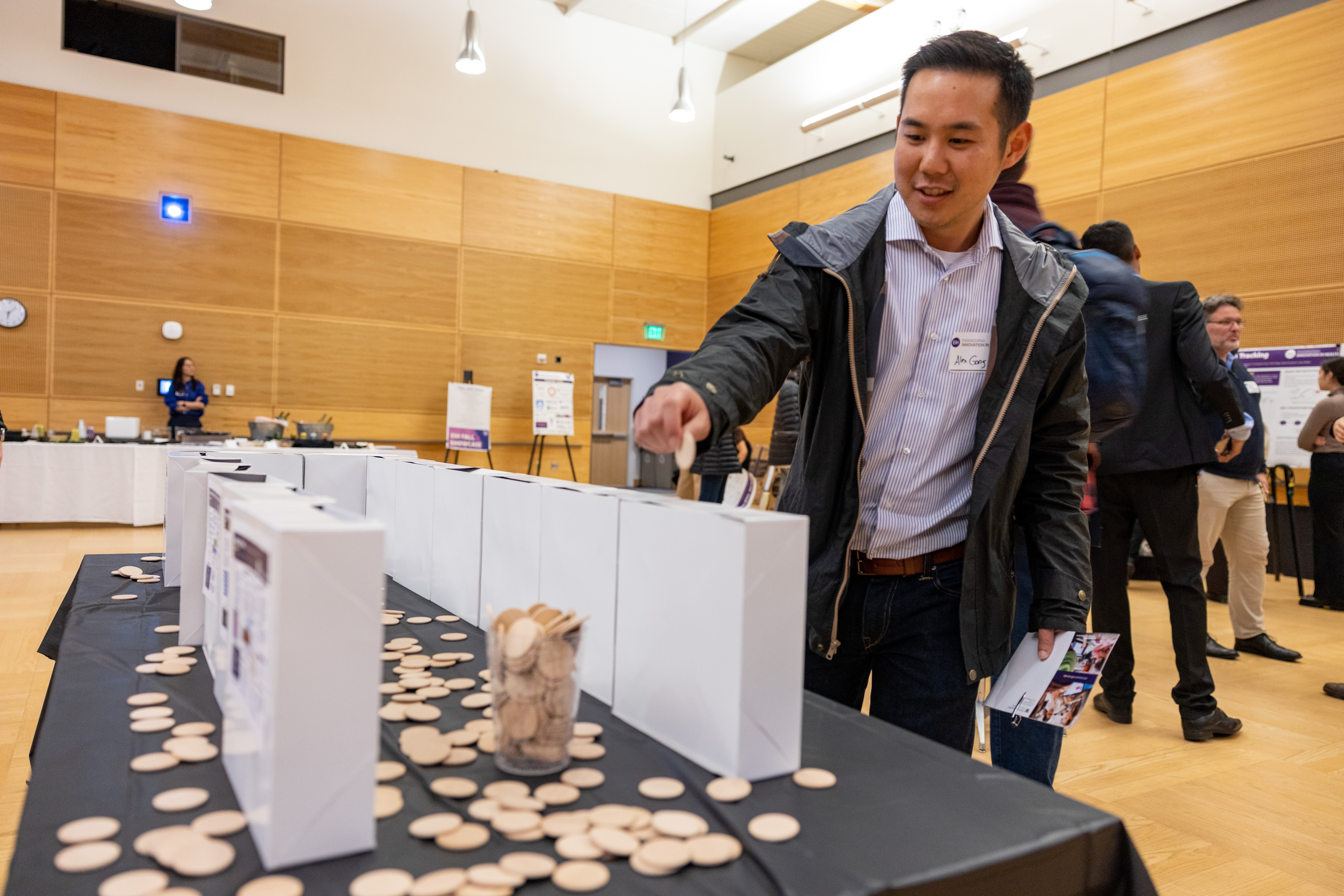 "Audience member placing card board chips in a box"